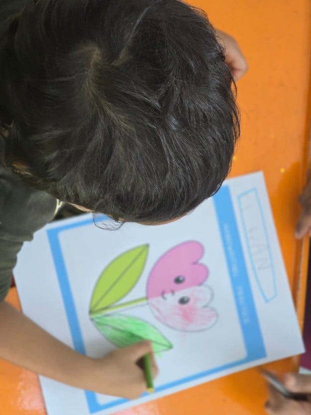 Child engaged in a coloring activity, coloring a flower worksheet with crayons to develop creativity, fine motor skills, and concentration