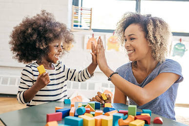 A therapist modeling natural language and connection with a child in a play session.