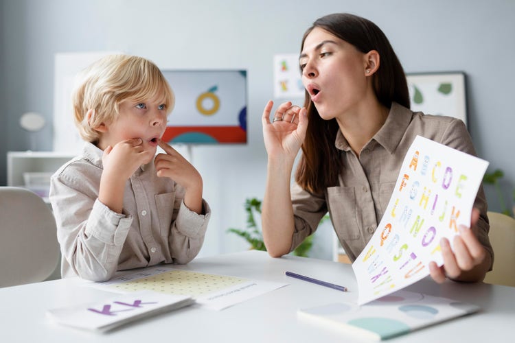 A pediatric speech therapist using colorful flashcards to improve articulation and language communication skills with a child.